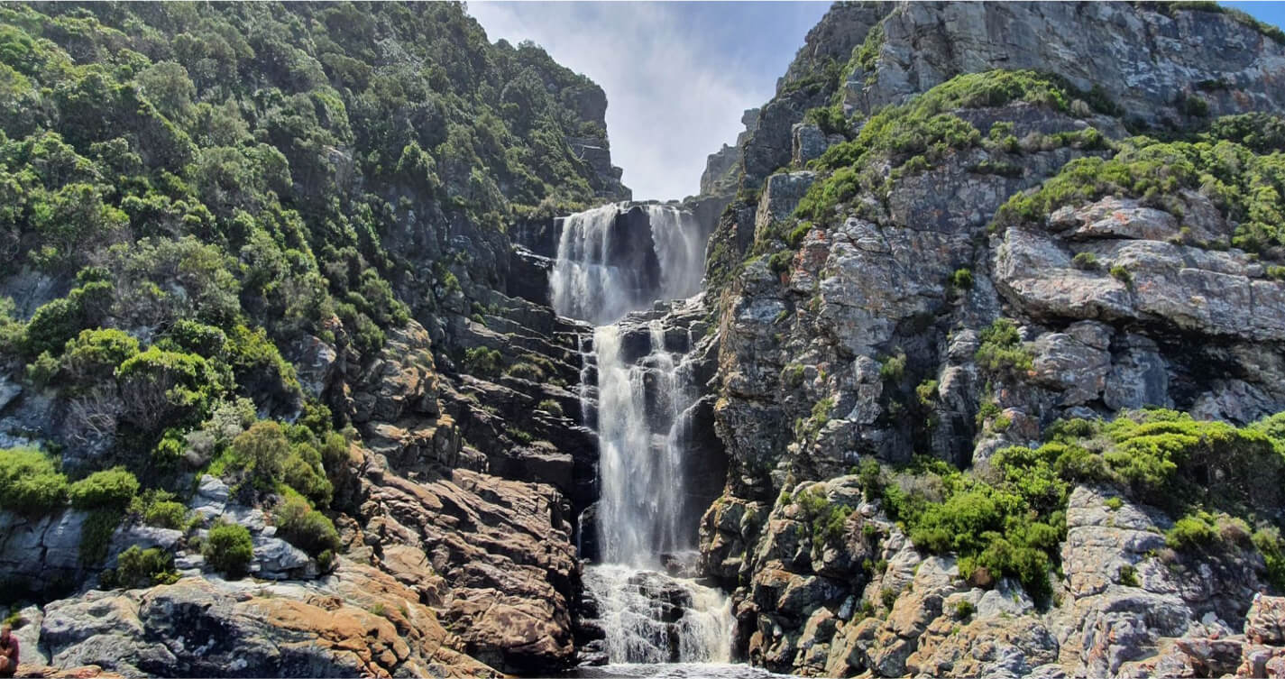 An exquisite waterfall formed between the gorge of two rocky mountains along one of the Knysna Sans Park hiking Trails.